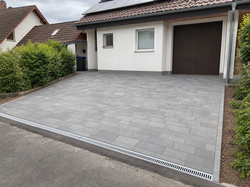 Gepflasterte Hofeinfahrt mit grauen Pflastersteinen