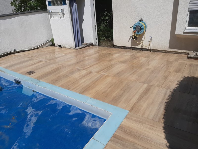 Detailansicht einer neu verlegten Poolumrandung in Holzoptik